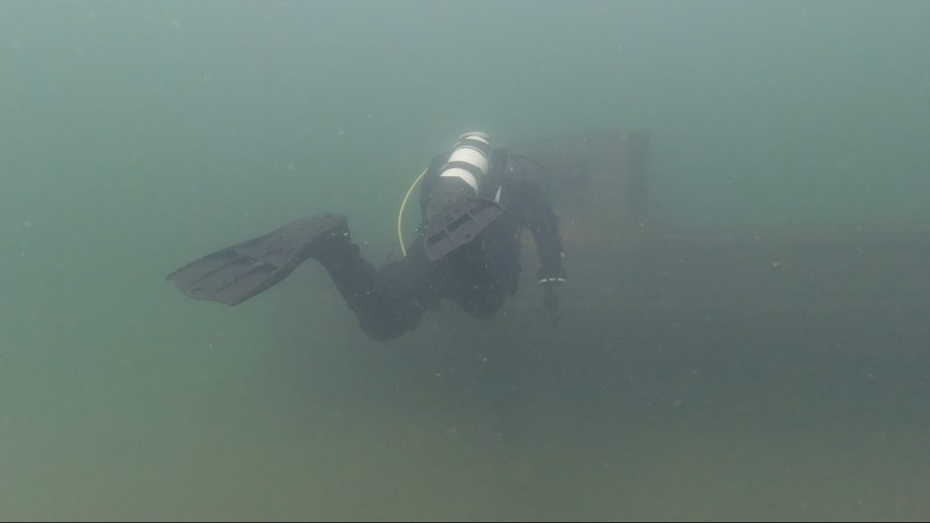 Diver swimming through green water at Leybourne Lakes