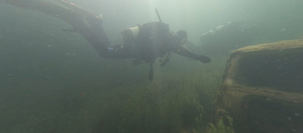 Diver navigating between sunken objects at Leybourne Lakes